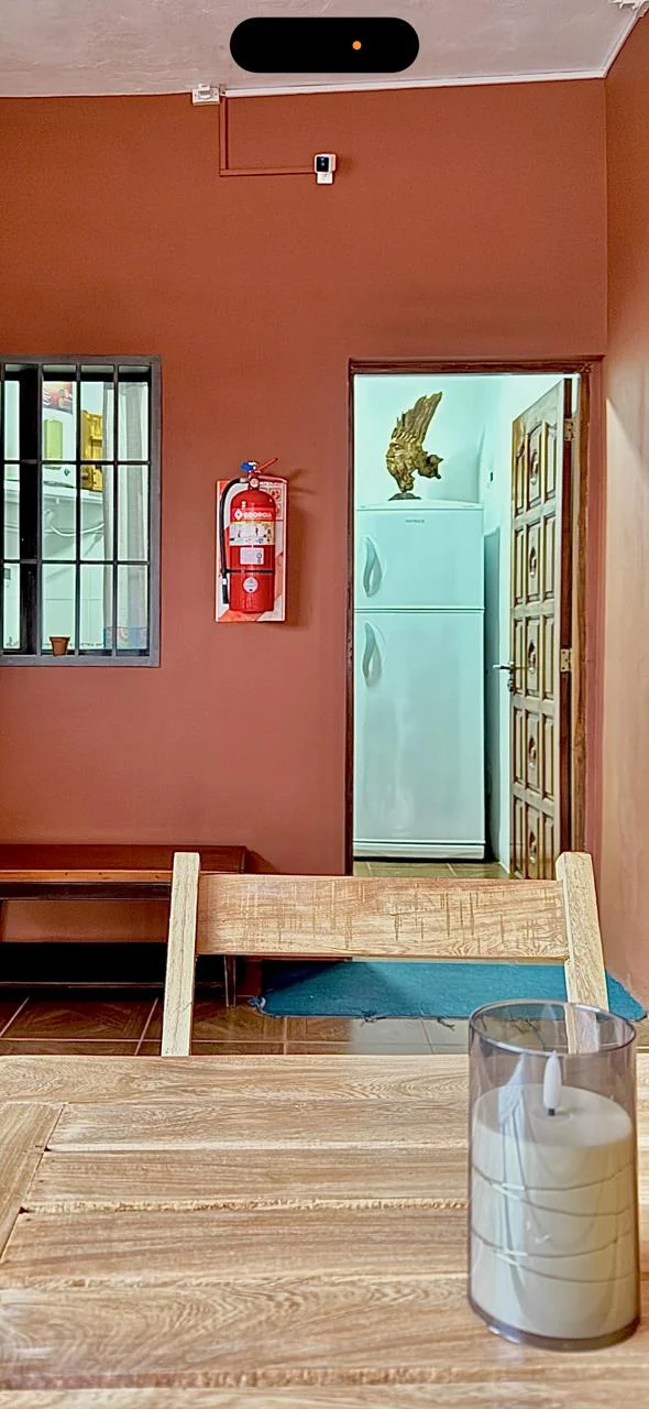 Comedor con mesa de madera y acceso a la cocina