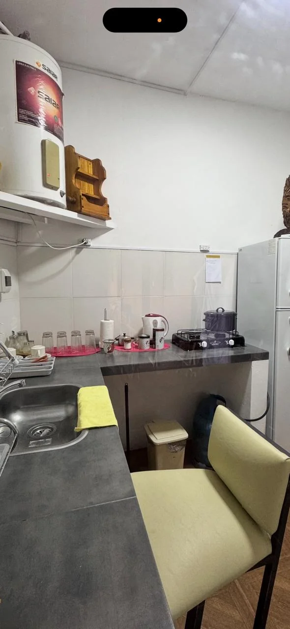 Cocina equipada con mesada, anafe, pava eléctrica y heladera