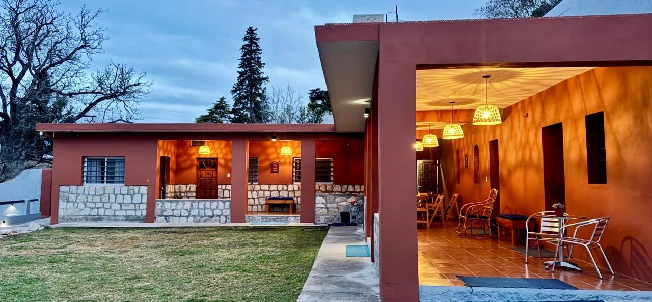 Vista exterior del alojamiento al atardecer con galería iluminada